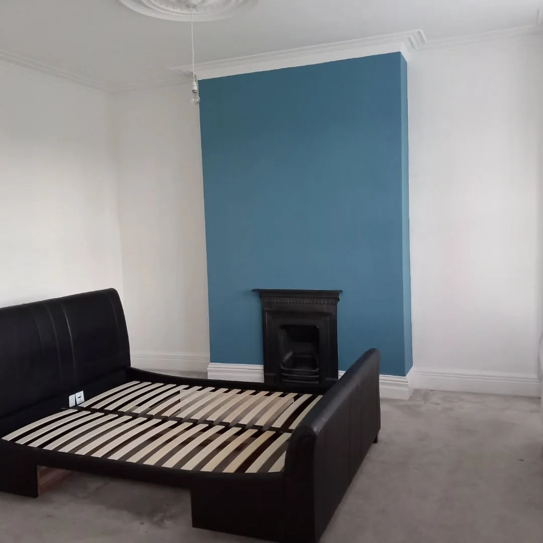 Bedroom with blue fireplace feature wall painted by Durham Painters